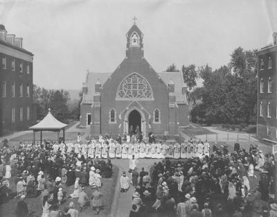 A line of newly ordained priests stands in front of Dahlgren Chapel