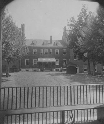 The Carroll Building at Georgetown University, also known as Old South, as seen from the porch of Old North, with the College pump shed on the right in 1874.