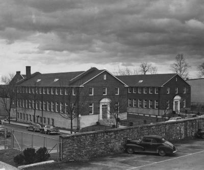 Black and white image of Poulton Hall in 1950 from the main lawn showing the stone wall and 37th Street in front of Poulton Hall.