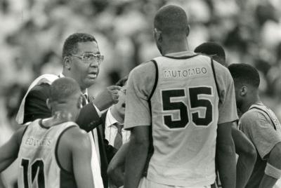 Coach Thompson speaks to Mutombo (#55) and teammates