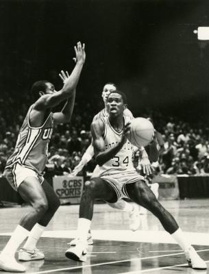 Williams (#34) is guarded near the hoop by an opposing player