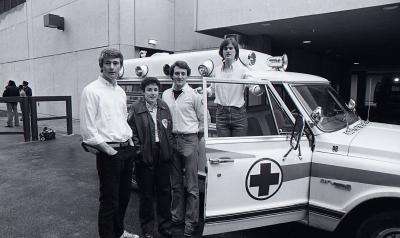 GERMS members pose for photo in front of ambulance Feb, 1984