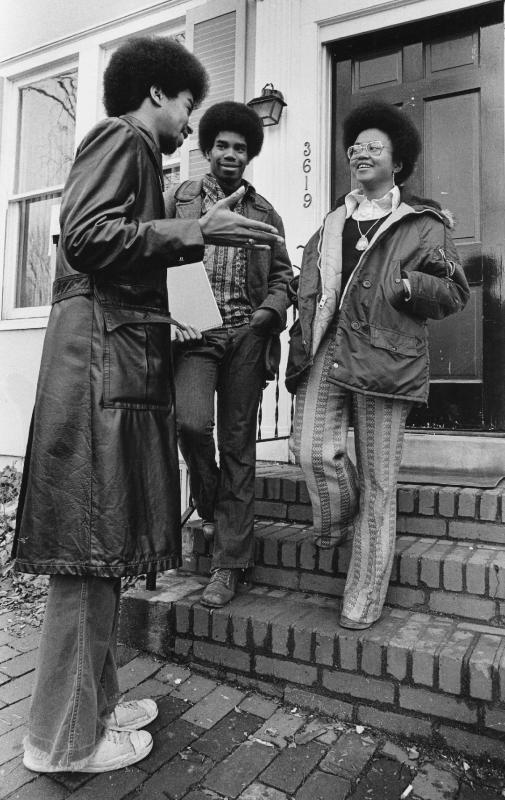 Depicts three BSA members standing and talking outside the Black House in 1973