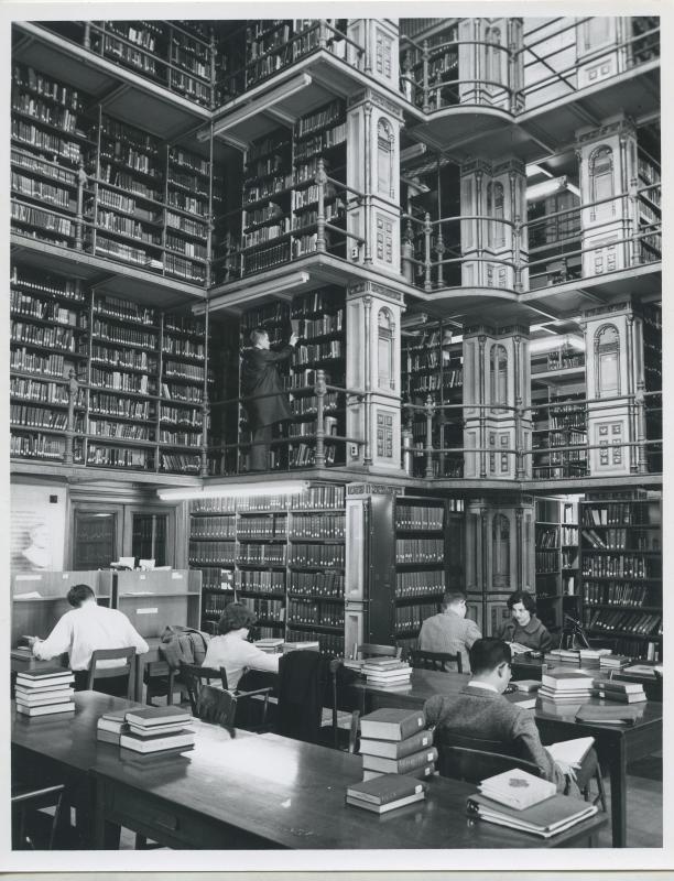 Photo of students studying in Riggs Library with book shelves in the backdrop